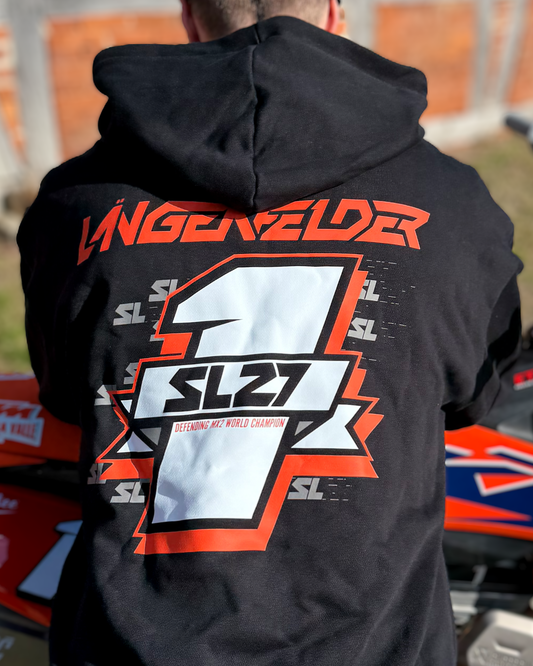 Schwarzer SL27 Hoodie „Number One“ mit großem Rückenprint: Schriftzug „Längenfelder“, markante Nummer 1 mit SL27-Logo und Zusatz „Defending MX2 World Champion“, fotografiert vor Backsteinwand neben einem Motocross-Bike.