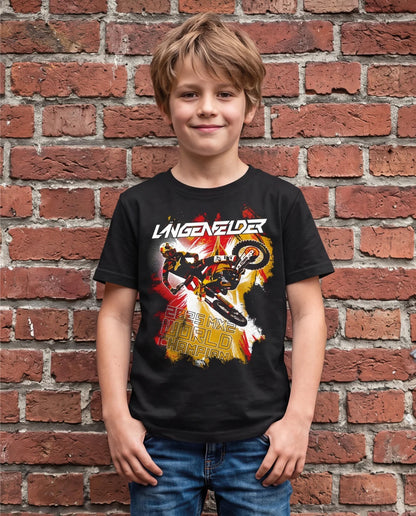 Kind trägt schwarzes SL27 „Kids HomeGP Germany“ T-Shirt mit großem Frontprint von Simon Längenfelder in Motocross-Action und „2025 MX2 World Champion“-Schriftzug vor einer Backsteinwand.