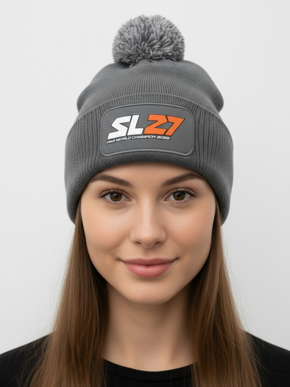 Graue SL27-Bommelmütze mit farblich passendem Pompon und schwarzem SL27-Gummipatch auf der Vorderseite, präsentiert vor hellem Hintergrund.